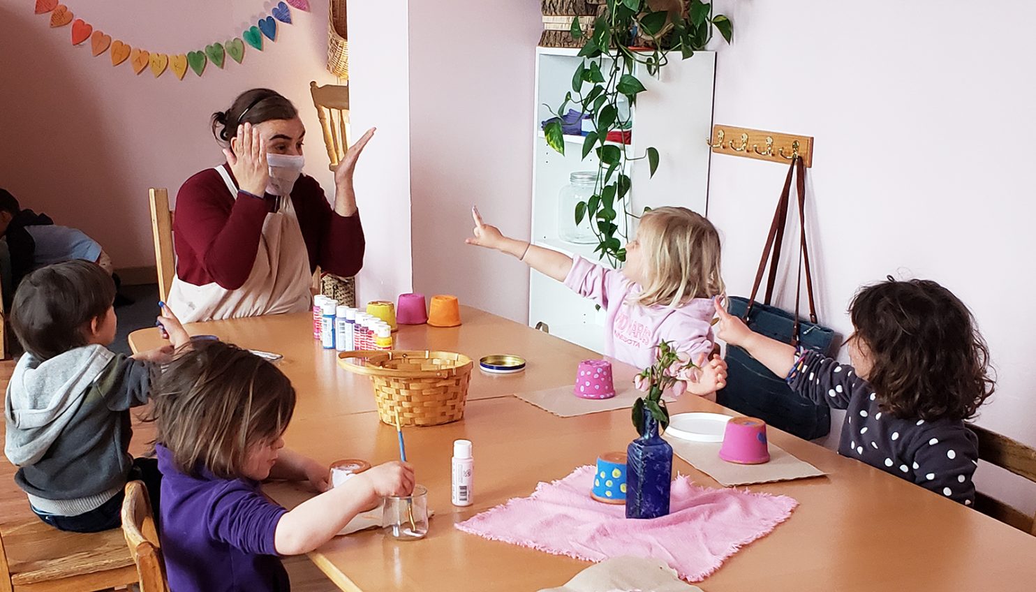 A preschool teacher plays a game with a group of happy and eager preschool students