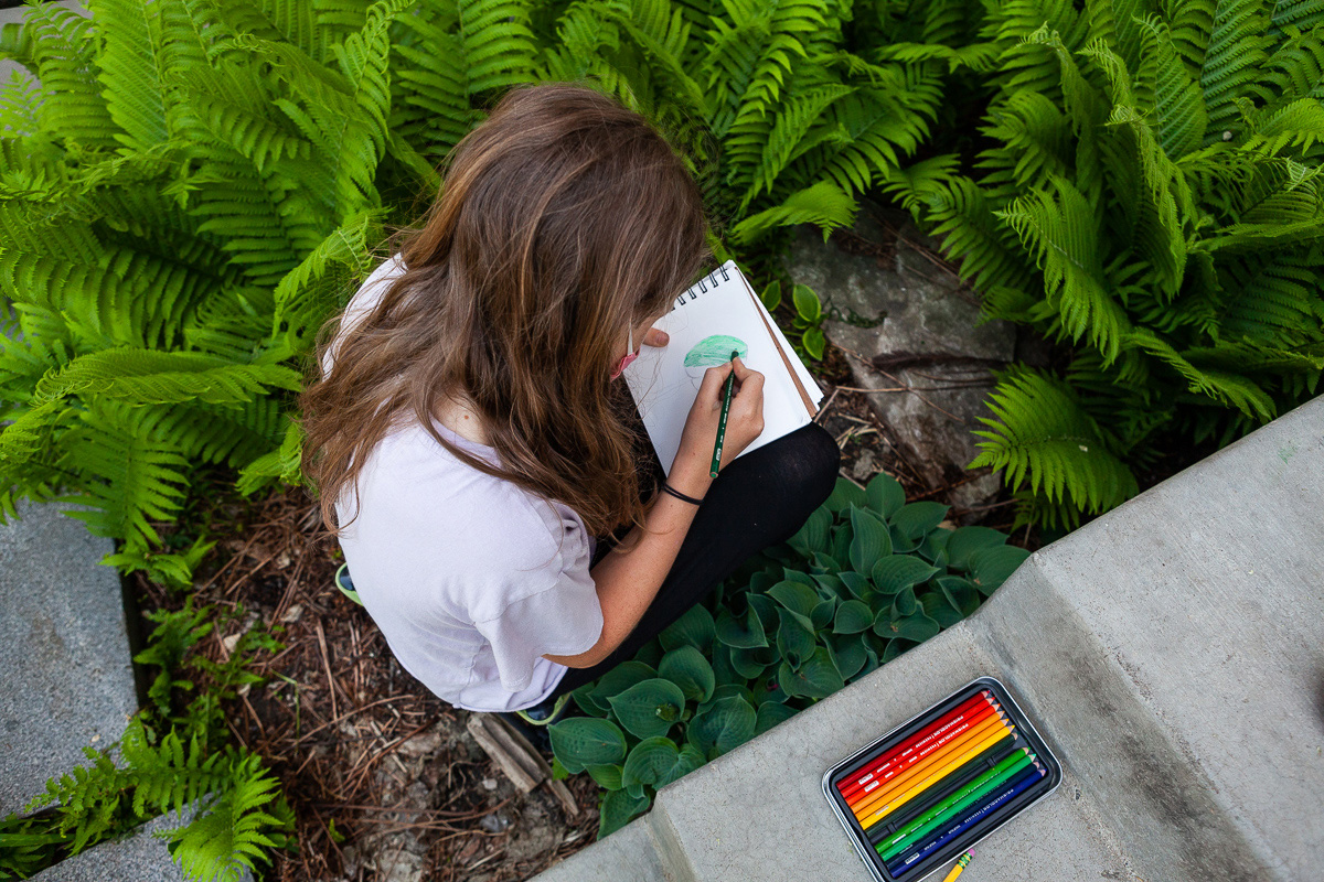 A CLWS 5th grade student works on a Botany assignment in the school's raingarden.