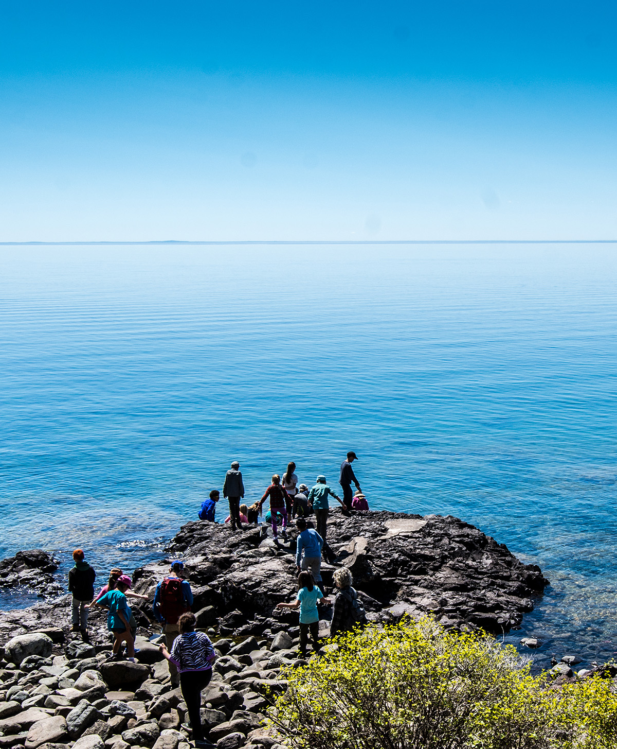 A group of students explores the rocky shores of Lake Superior