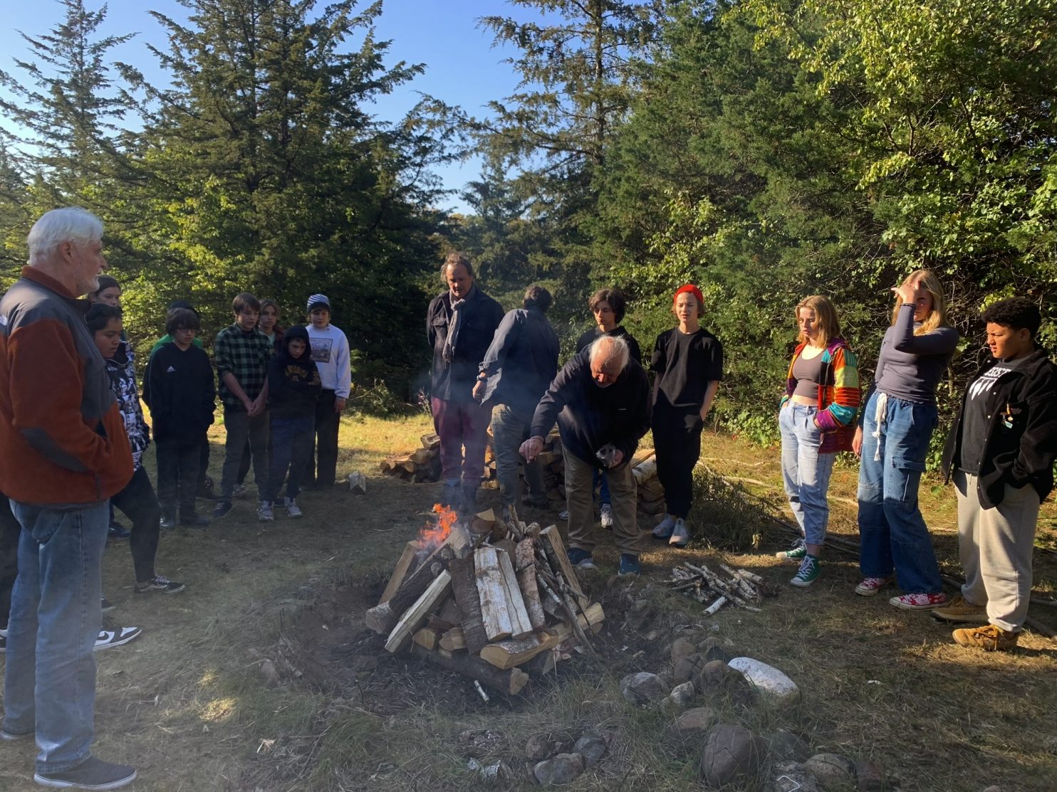 The 8th grade students gather around the fire