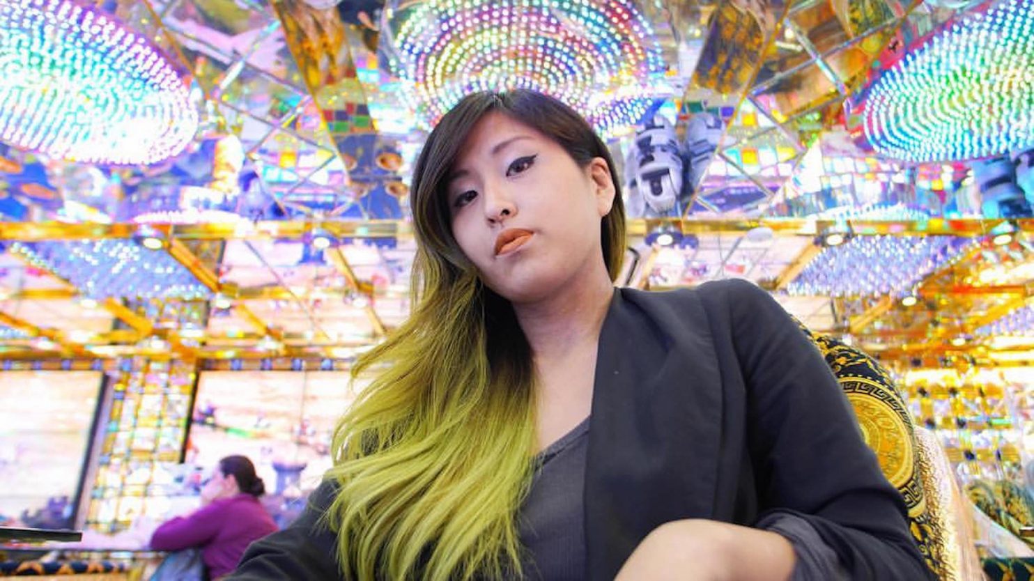 Yoko Okumura, pictured under a beautiful ceiling with multicolored light fixtures