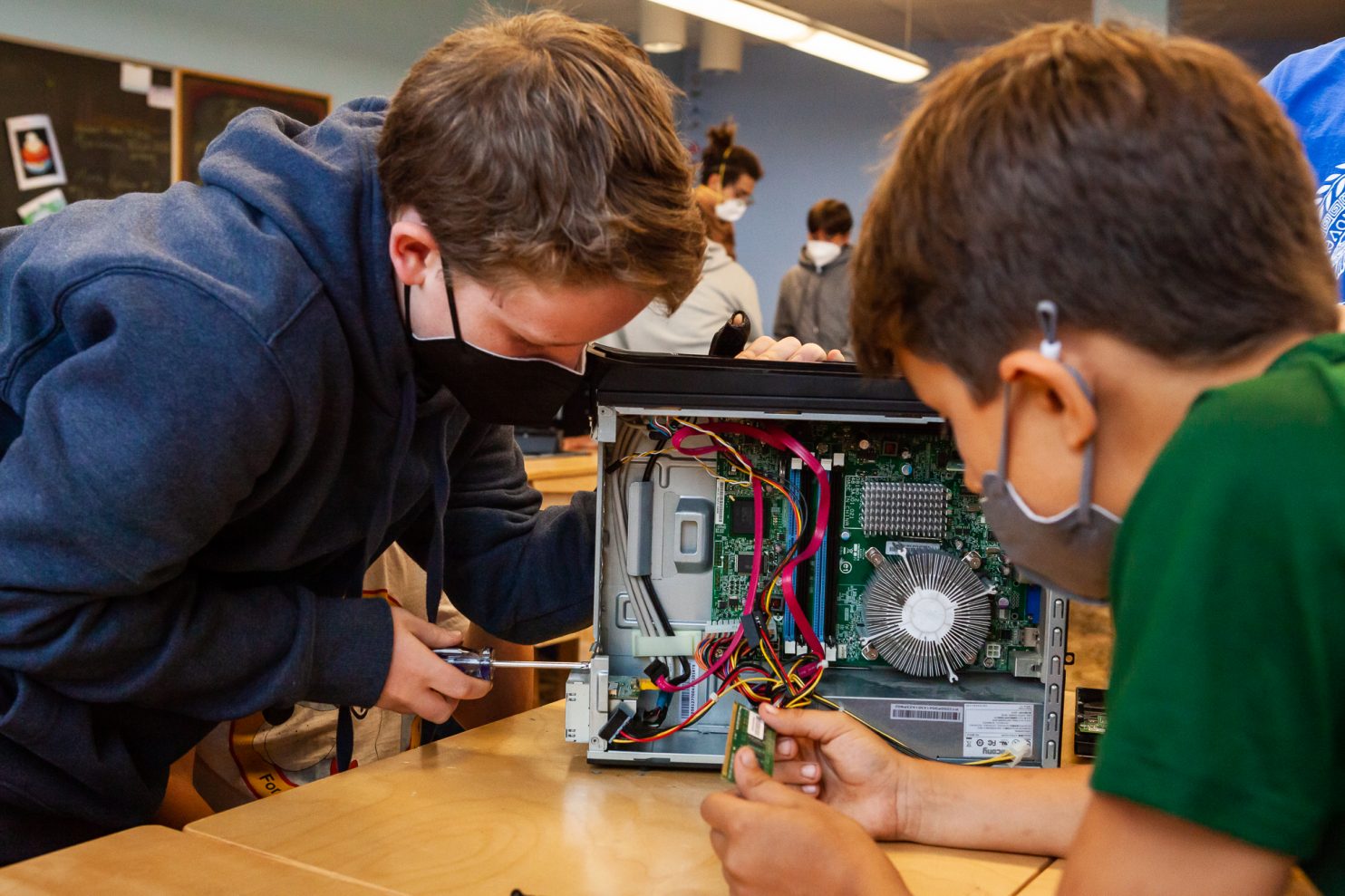 Two students take apart a computer during Cyber Civics class